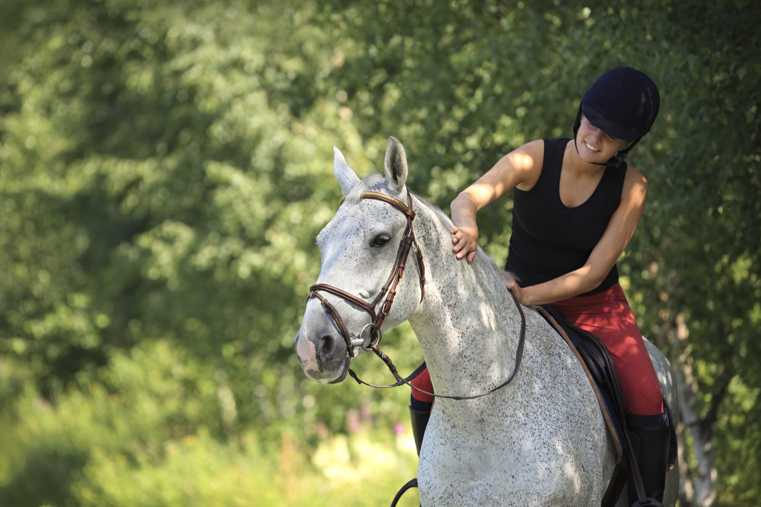 Jongedame die blij is om op haar mooie paard te rijden